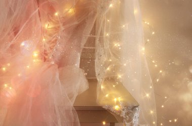 Güzel beyaz gelinlik ve peçe sandalyede altın garland ışıkları ile