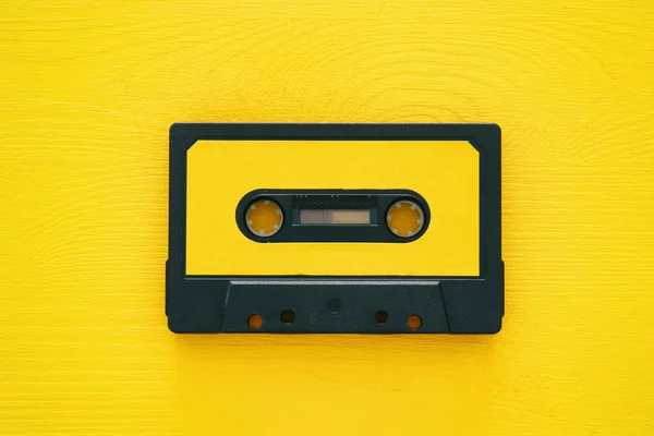 Retro cassette tape over yellow wooden table. top view. — Stock Photo, Image