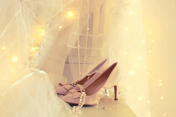 Krásné bílé svatební šaty a závoj na židli s zlatý věnec světel — Stock fotografie