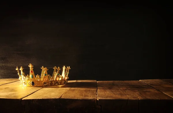 Bassa chiave di regina / re corona sopra tavolo di legno. vintage filtrato. fantasia periodo medievale — Foto Stock