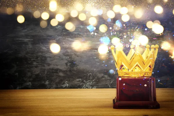 Bild av gyllene krona utmärkelse över träbord — Stockfoto
