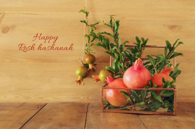 Rosh hashanah (jewesh yeni yıl tatili) kavramı - nar ahşap arka plan üzerinde. Geleneksel sembolü