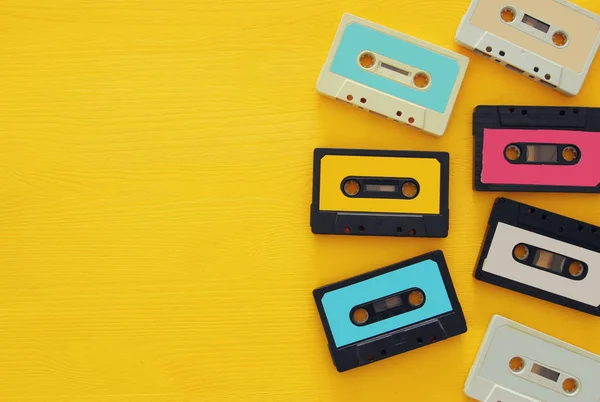 Retro cassette tape collection over yellow wooden table. top view. copy space — Stock Photo, Image