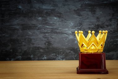 Tahta masanın üzerinde altın taç resmi