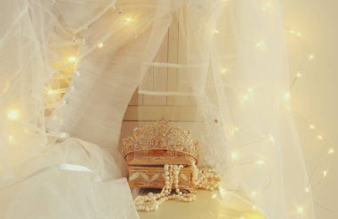 Güzel beyaz gelinlik ve peçe sandalyede altın garland ışıkları ile