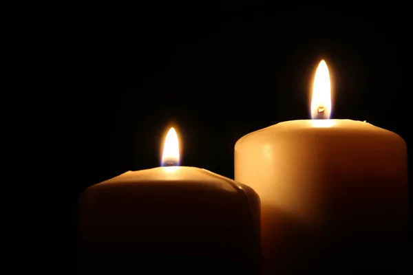 Burning candles over black background with bokeh lights — Stock Photo, Image