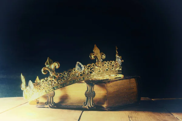 Clé basse de reine / couronne de roi sur le vieux livre. vintage filtré. fantaisie période médiévale — Photo