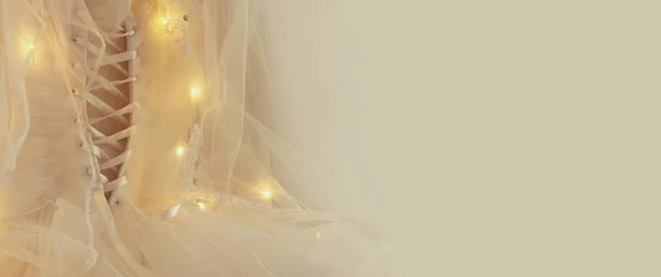 Hermoso vestido de novia blanco y velo en silla con luces de guirnalda —  Fotos de Stock