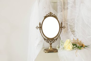 Eski vintage oval ayna ve güzel beyaz gelinlik ve peçe sandalyede