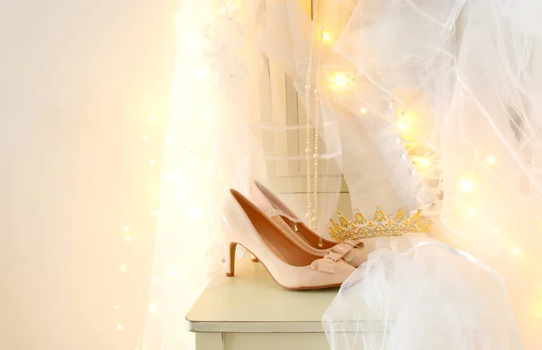 Hermoso vestido de novia blanco y velo en silla con luces de guirnalda de oro —  Fotos de Stock