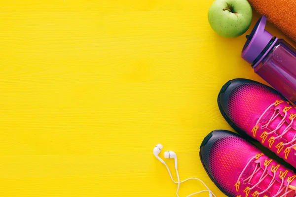 şişe su, havlu ve kadın pembe spor ayakkabı renkli arka plan üzerinde Fitness kavramı