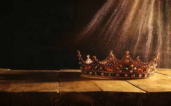 Bassa chiave di bella regina / re corona sopra tavolo di legno. vintage filtrato. fantasia periodo medievale — Foto Stock