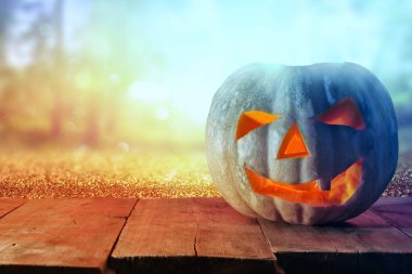 Cadılar Bayramı Balkabağı korkunç koyu arka plan önünde tahta masada. Jack o fener