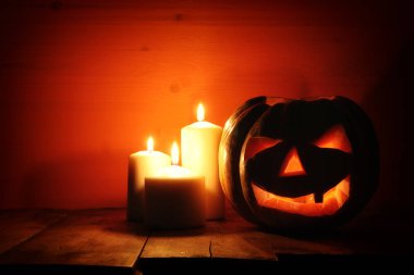 Cadılar Bayramı Balkabağı korkunç koyu arka plan önünde tahta masada. Jack o fener