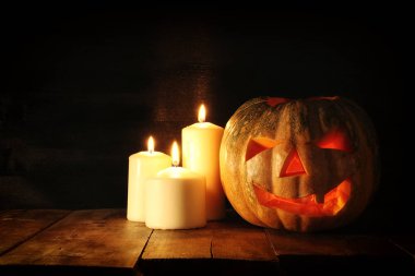 Cadılar Bayramı Balkabağı korkunç koyu arka plan önünde tahta masada. Jack o fener