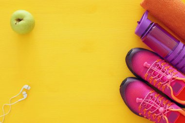 şişe su, havlu ve kadın pembe spor ayakkabı renkli arka plan üzerinde Fitness kavramı