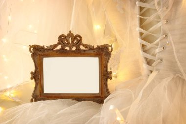 Eski vintage oval ayna ve güzel beyaz gelinlik ve peçe sandalyede altın garland ışıkları ile