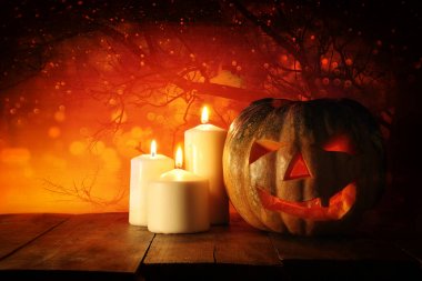 Cadılar Bayramı Balkabağı korkunç koyu arka plan önünde tahta masada. Jack o fener