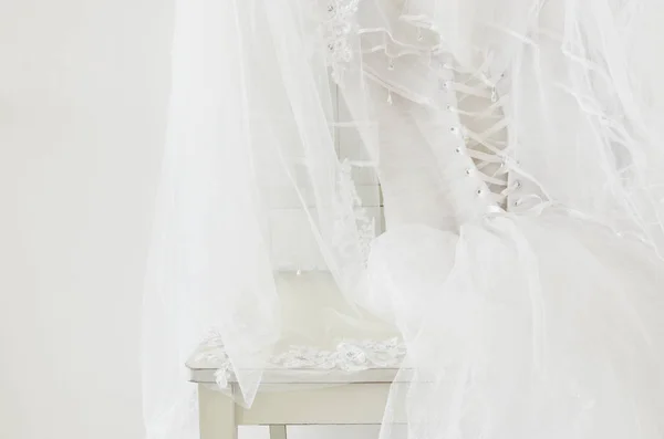 Beautiful white wedding dress and veil on chair — Stock Photo, Image