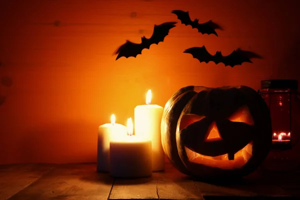 Abóbora de Halloween na mesa de madeira na frente de fundo escuro assustador. Jack o lanterna — Fotografia de Stock