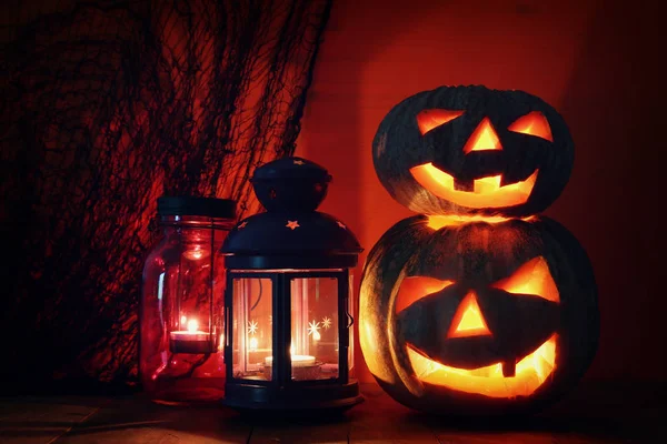 Halloween pumpa på träbord framför spöklikt mörk bakgrund. Jack o lantern — Stockfoto