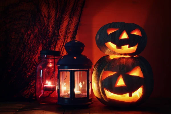 Zucca di Halloween sul tavolo di legno di fronte a sfondo scuro spettrale. Jack o lanterna — Foto Stock