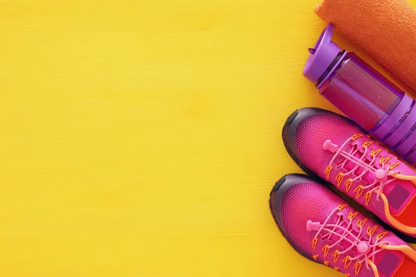 Γυμναστήριο έννοια με μπουκάλι νερό, πετσέτα και γυναίκα ροζ αθλητικά παπούτσια σε ζωηρά χρώματα φόντου — Φωτογραφία Αρχείου