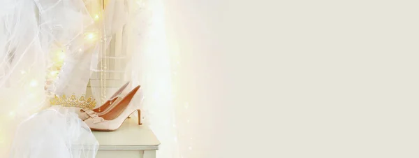 Mooie witte bruiloft jurk en sluier op stoel met gouden garland lichten — Stockfoto