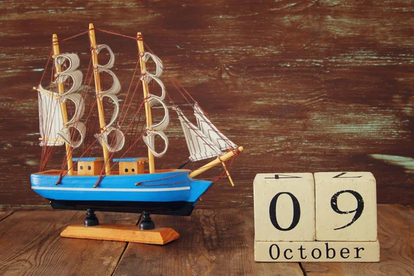 Kolomb Günü kavramı eski gemiye el ahşap arka plan ile