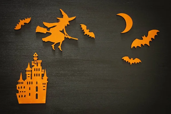 Conceito de feriado de Halloween cena vista superior. Velho castelo, bruxa, morcegos em fundo preto de madeira — Fotografia de Stock