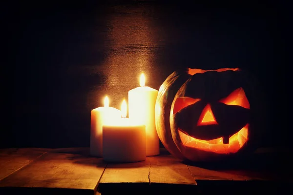 Halloween pompoen op houten tafel spooky donkere achtergrond. Jack o lantern — Stockfoto