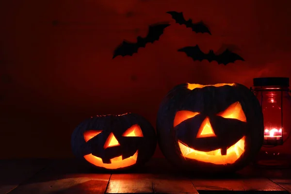 Calabaza de Halloween en la mesa de madera frente al espeluznante fondo oscuro. Jack o linterna — Foto de Stock