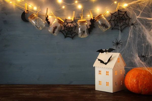 Concetto di festa di Halloween. Misteriosa casa con luci di fronte a vasi di massoni con ragni, bagni — Foto Stock