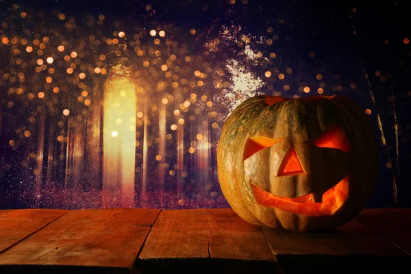 Zucca di Halloween sul tavolo di legno di fronte a sfondo scuro spettrale. Jack o lanterna — Foto Stock
