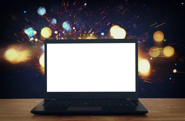 Offener Laptop mit weißem Bildschirm auf Holztisch vor abstraktem Glitzerhintergrund — Stockfoto