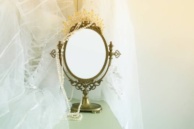 Eski vintage oval ayna ve güzel beyaz gelinlik ve peçe sandalyede. Kopya alanı sahte kadar montaj veya tasarım düzeni için