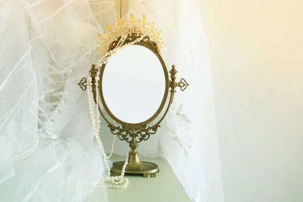 Staré retro oválné zrcadlo a krásné bílé svatební šaty a závoj na židli. Kopírovat prostor pro vzorovou, rozložení fotomontáž nebo návrhu — Stock fotografie