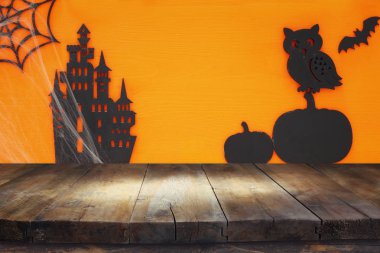 Cadılar Bayramı tatil kavramı boş rustik masa üzerinde turuncu arka plan ile. Ürün görüntü montaj için hazır