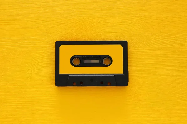 Ретро-касетна стрічка над жовтим дерев'яним столом. вид зверху. копіювання простору — стокове фото
