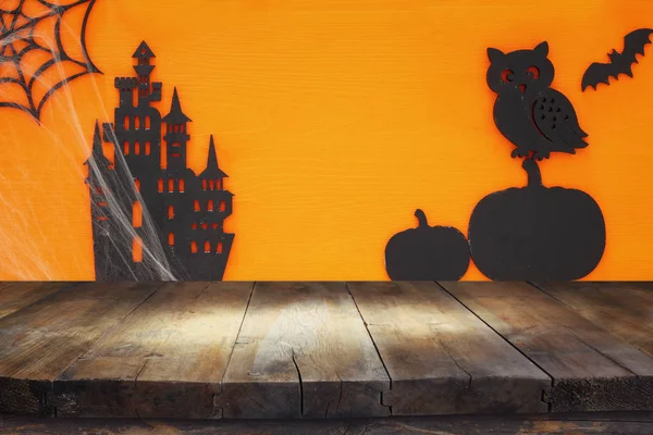 Cadılar Bayramı tatil kavramı boş rustik masa üzerinde turuncu arka plan ile. Ürün görüntü montaj için hazır