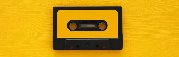 Fita cassete retrô sobre mesa de madeira amarela. vista superior. espaço de cópia — Fotografia de Stock