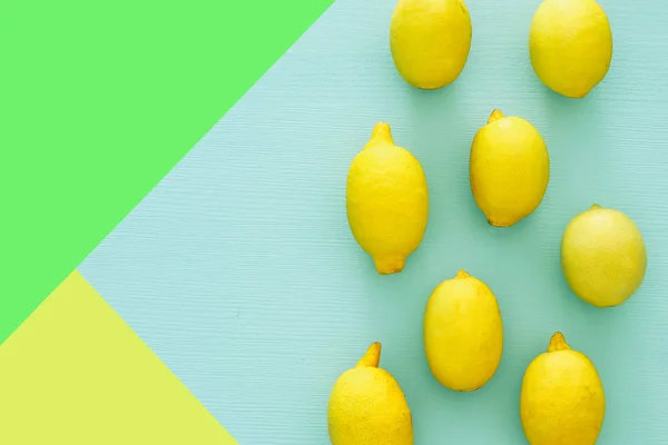 青い木製の背景の上に新鮮なレモンの平面図. — ストック写真