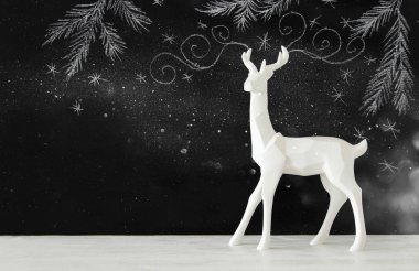 Kara tahta arka plan whith el üzerinde ahşap masa üzerinde beyaz Ren geyiği tebeşir illüstrasyonlar çizilmiş