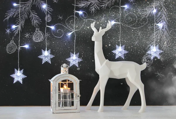 Kara tahta arka plan whith el üzerinde ahşap masa üzerinde beyaz Ren geyiği tebeşir illüstrasyonlar çizilmiş