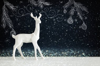 Kara tahta arka plan whith el üzerinde ahşap masa üzerinde beyaz Ren geyiği tebeşir illüstrasyonlar çizilmiş.