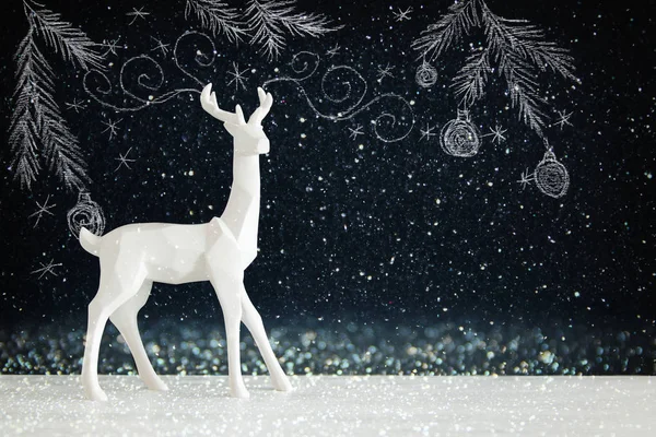 Kara tahta arka plan whith el üzerinde ahşap masa üzerinde beyaz Ren geyiği tebeşir illüstrasyonlar çizilmiş.