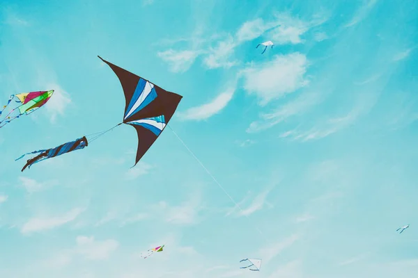 Colorful kite flying in the blue sky through the clouds — Stock Photo, Image