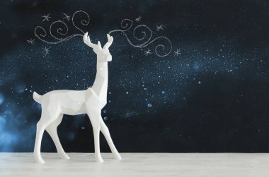 Kara tahta arka plan whith el üzerinde ahşap masa üzerinde beyaz Ren geyiği tebeşir illüstrasyonlar çizilmiş