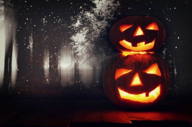 Cadılar Bayramı Balkabağı korkunç koyu arka plan önünde tahta masada. Jack o fener