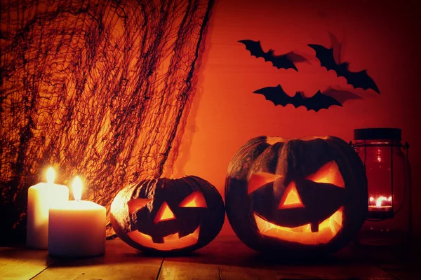 Calabaza de Halloween en la mesa de madera frente al espeluznante fondo oscuro. Jack o linterna — Foto de Stock